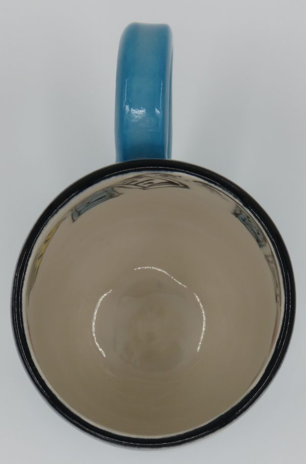 The Outside is Turquoise on the bottom and Pansy Blue on top. The inside is white and has a prayer flag design. Mug Measures approx. 4" tall x 5 1/2" wide to edge of handle and approx. 3 1/4" in diameter.