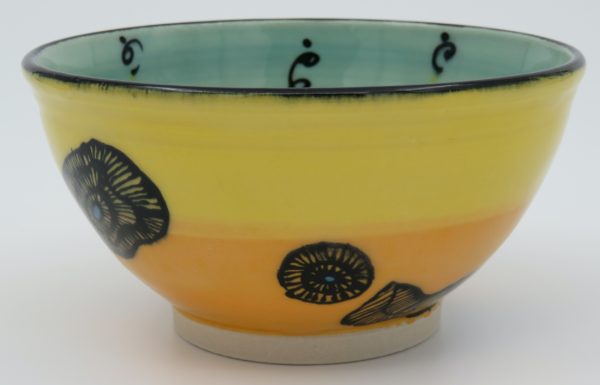 This bowl is a good size for serving small portions of things. It measures approximately, 5" in diameter x 2 3/4" tall. The outside is Tangerine on the bottom and Buttercup on the top. It has a random abstract black line drawing design with turquoise accents. The inside is Sea Grass on Top and Red on the bottom and has an open flower and more abstract line drawings.