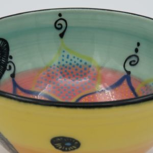 This bowl is a good size for serving small portions of things. It measures approximately, 5" in diameter x 2 3/4" tall. The outside is Tangerine on the bottom and Buttercup on the top. It has a random abstract black line drawing design with turquoise accents. The inside is Sea Grass on Top and Red on the bottom and has an open flower and more abstract line drawings.