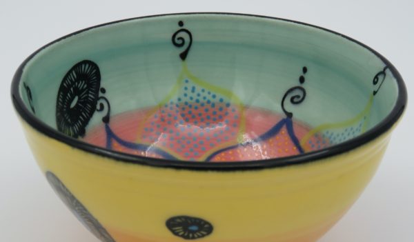 This bowl is a good size for serving small portions of things. It measures approximately, 5" in diameter x 2 3/4" tall. The outside is Tangerine on the bottom and Buttercup on the top. It has a random abstract black line drawing design with turquoise accents. The inside is Sea Grass on Top and Red on the bottom and has an open flower and more abstract line drawings.